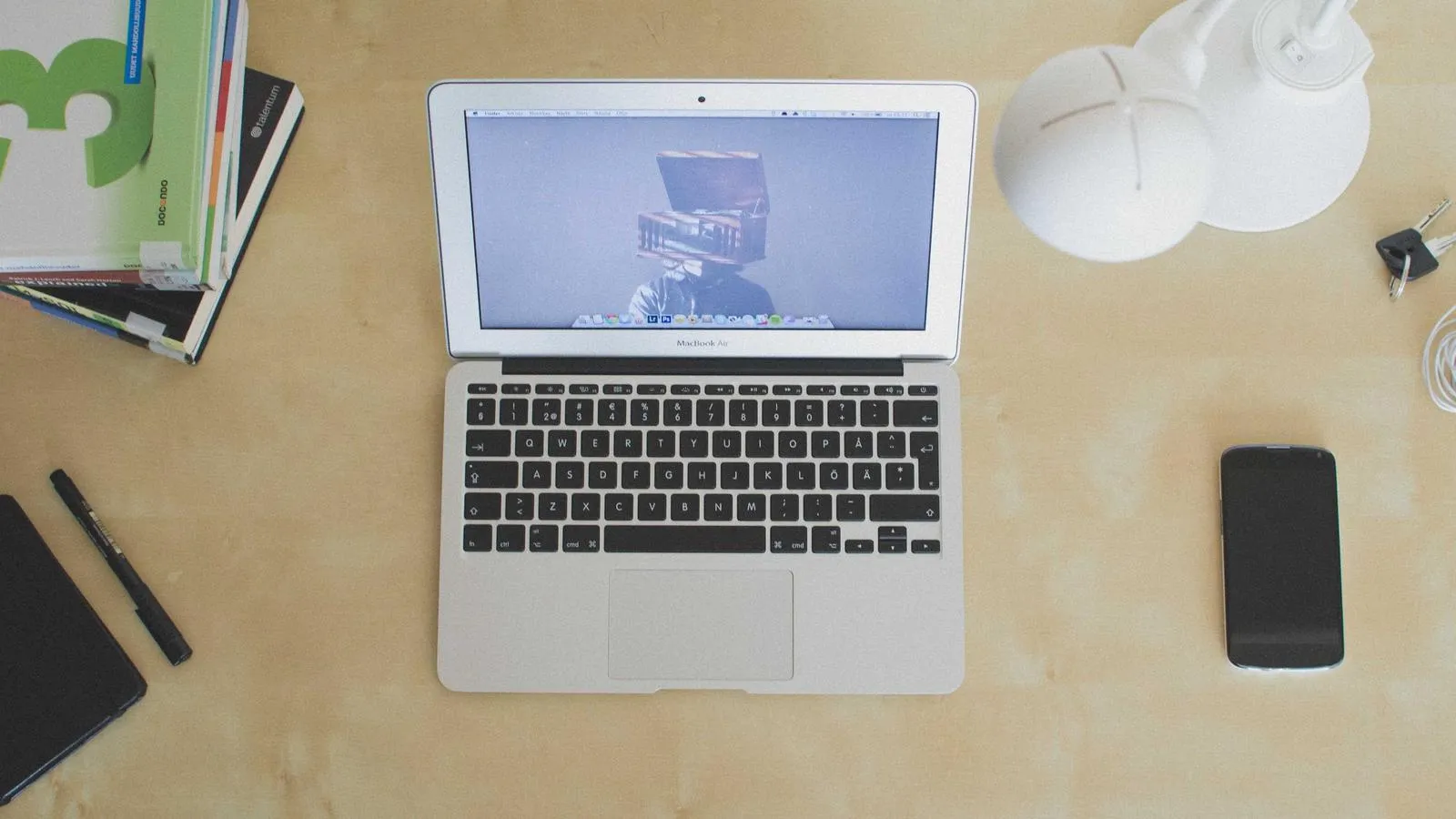 A laptop showing a content calendar beside a second screen with a post being composed